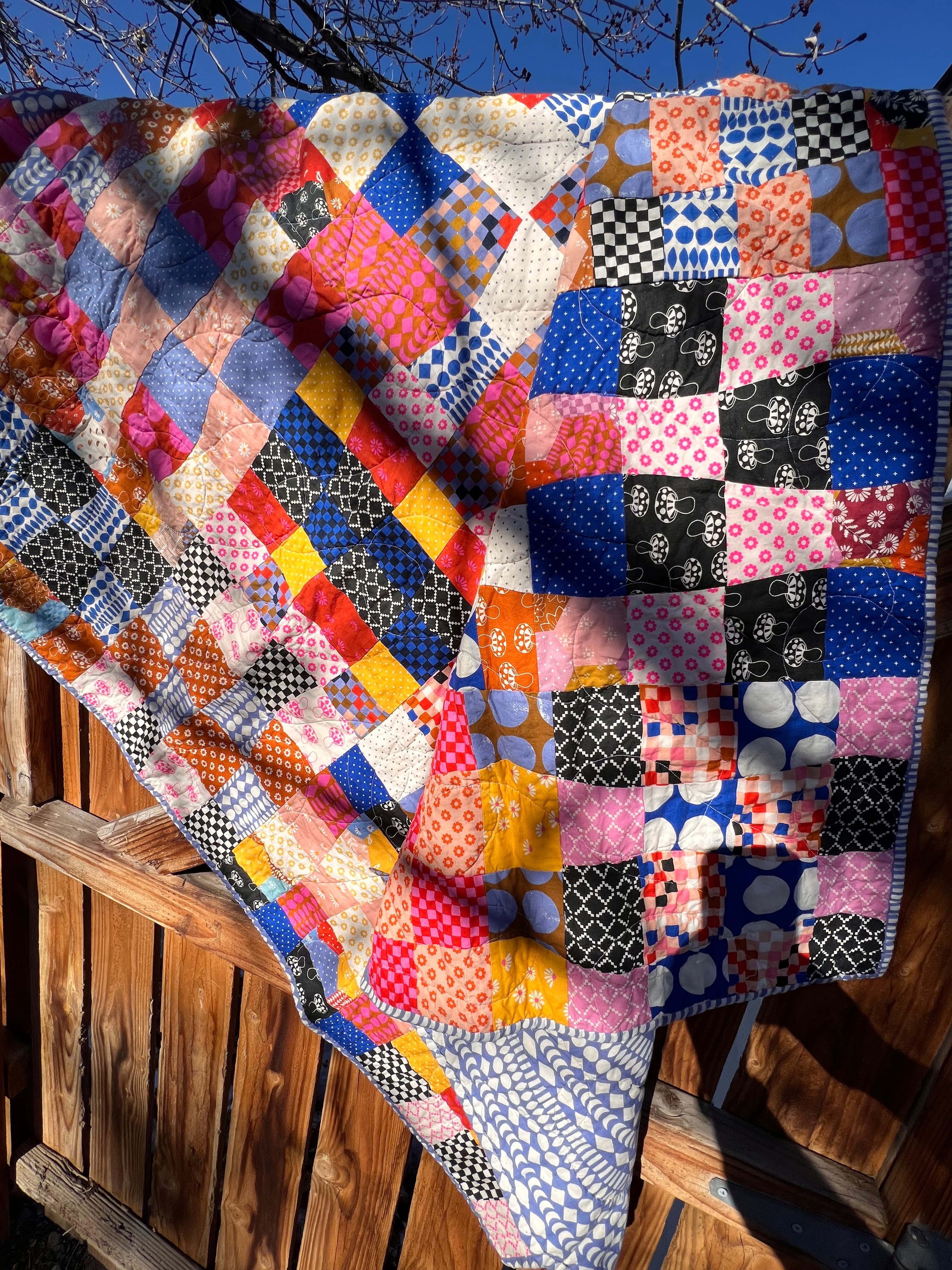 Quilt of wavy squares, with a scrappy pallette.