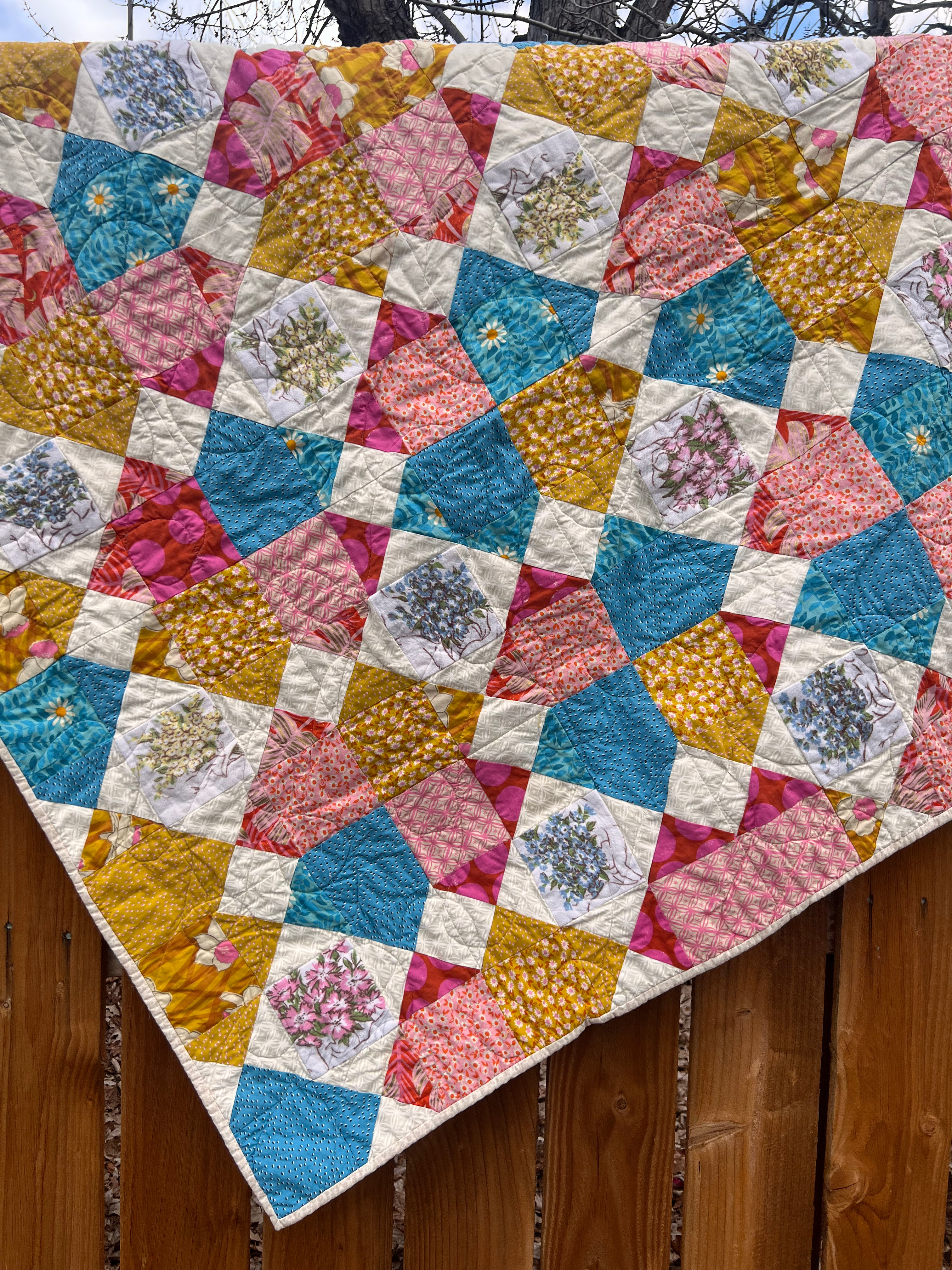 Quilt of squares and trinagles, with a blue, yellow, and red color pallette.