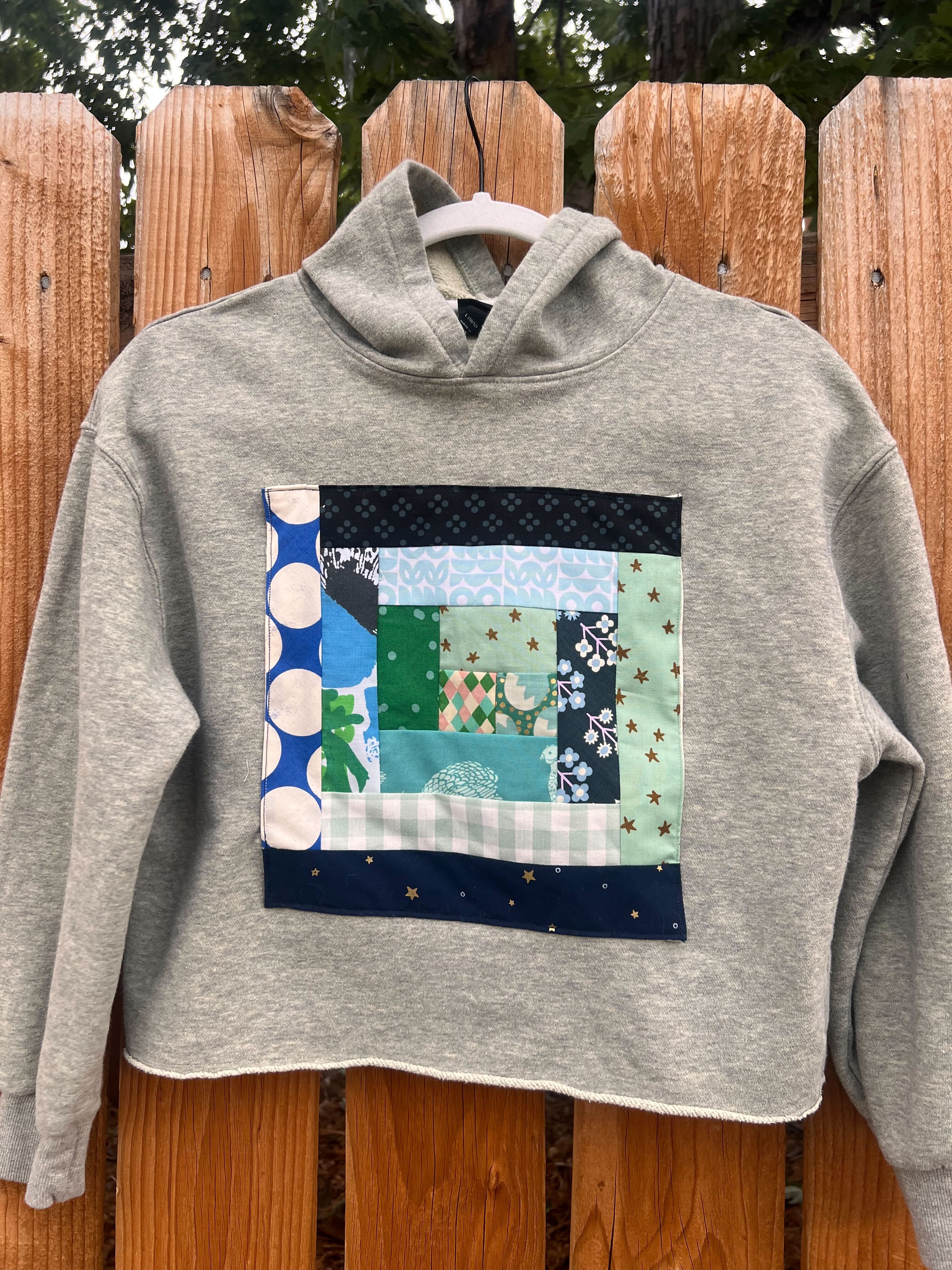 Hooded sweater with log cabin quilted front.