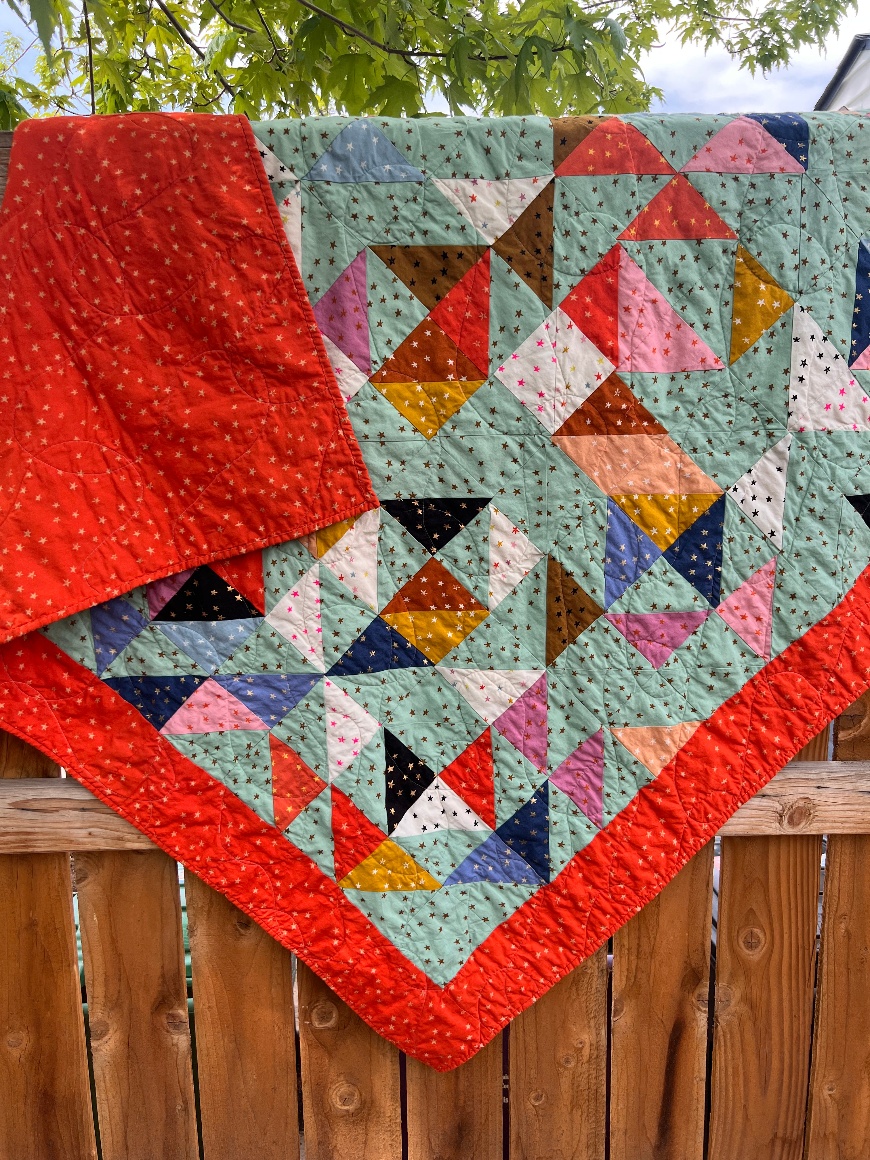 Quilt of trinagles, with a scrappy pallette.